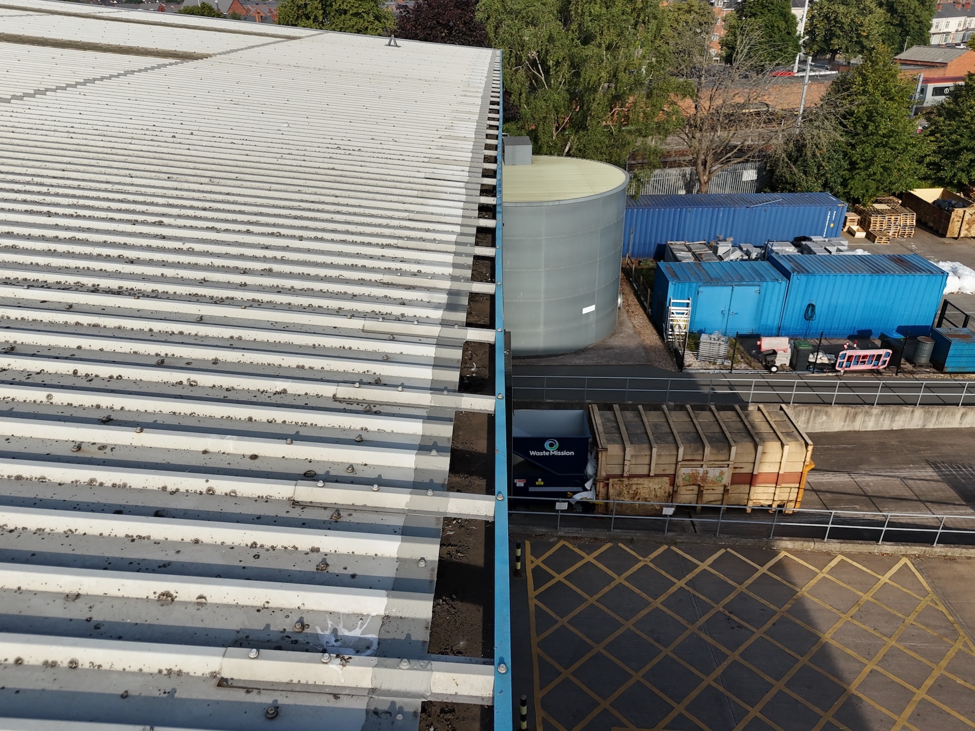 Drone view of industrial roof and surrounding plant equipment during survey