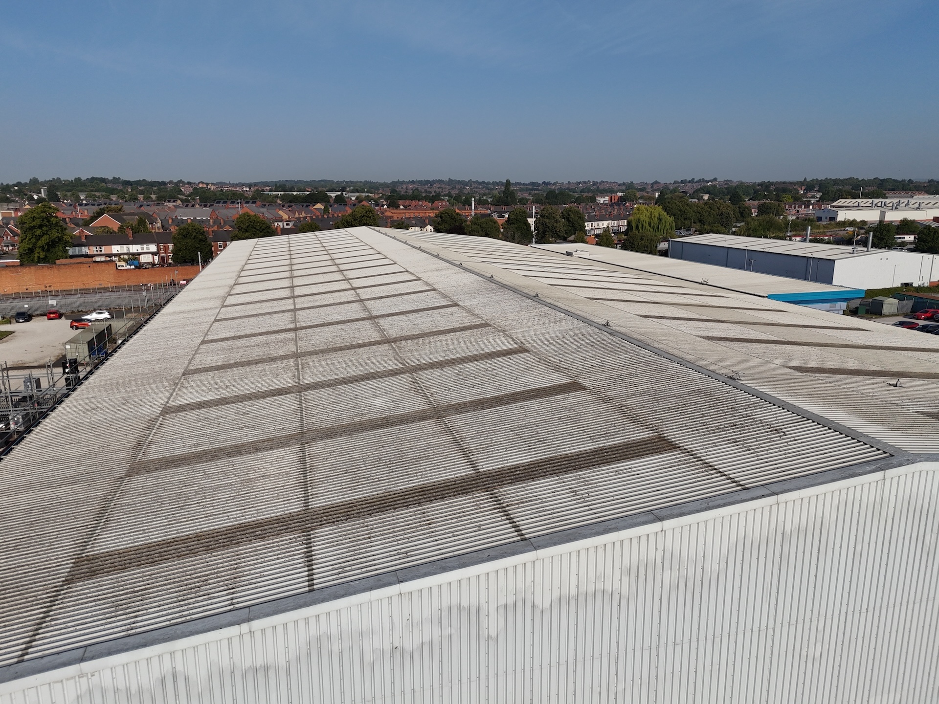 Drone view along flat roof surface showing condition and drainage layout
